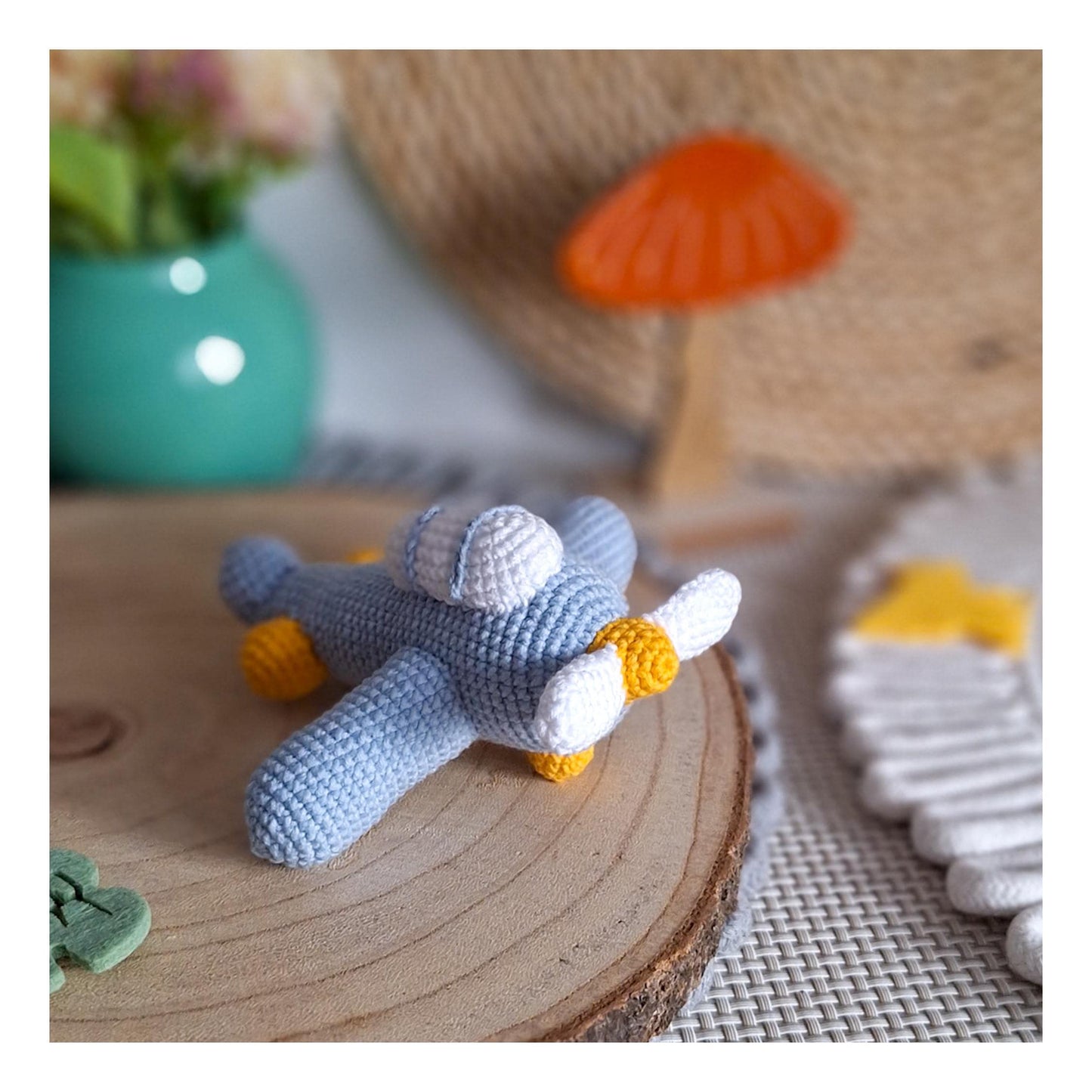 Crochet aircraft keychain photographed on wooden background