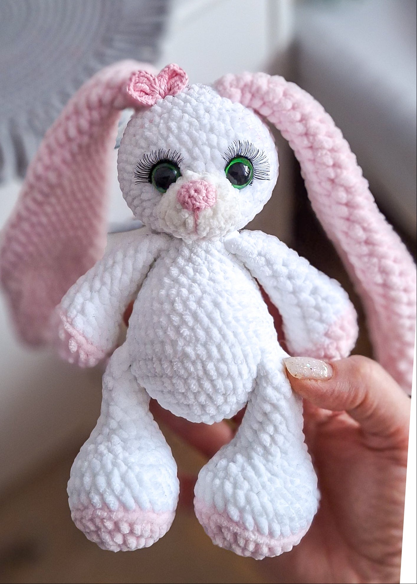 White amigurumi bunny plush toy with pink accents and floppy ears
